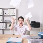 Woman throwing papers in frustration